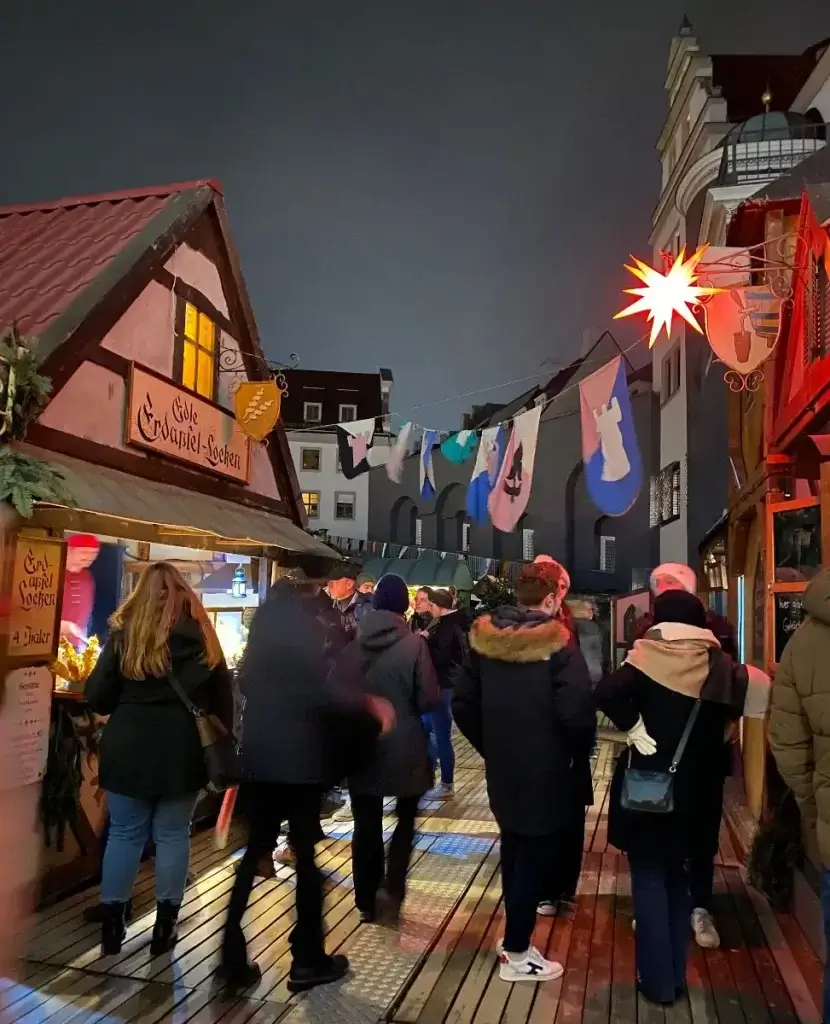 A group of revellers walking through an alley at Dresden's Middle Ages Christmas Market.