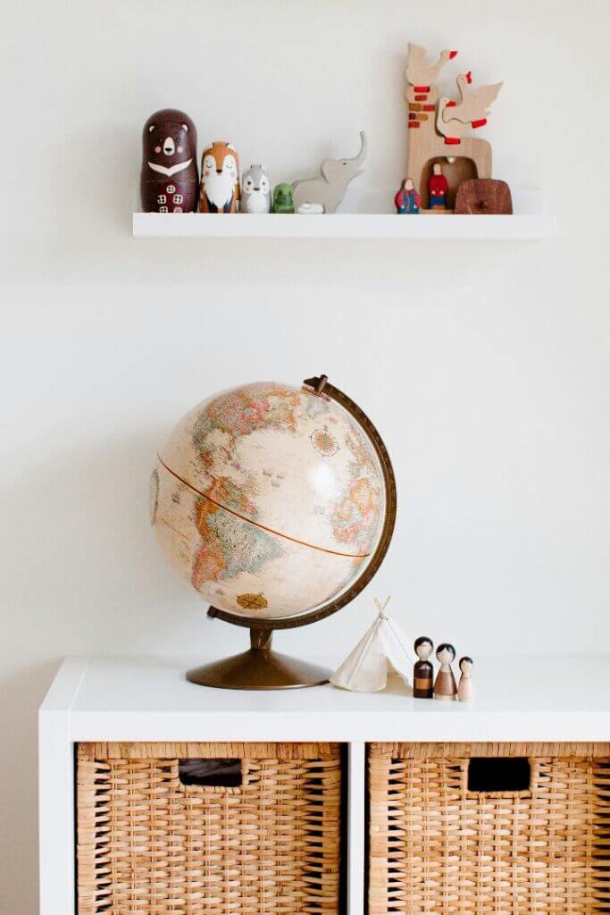 A picture of a globe and a small doll family.