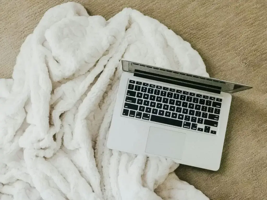 Laptop and blanket ready for an online therapy session to help a woman build her expat support network.
