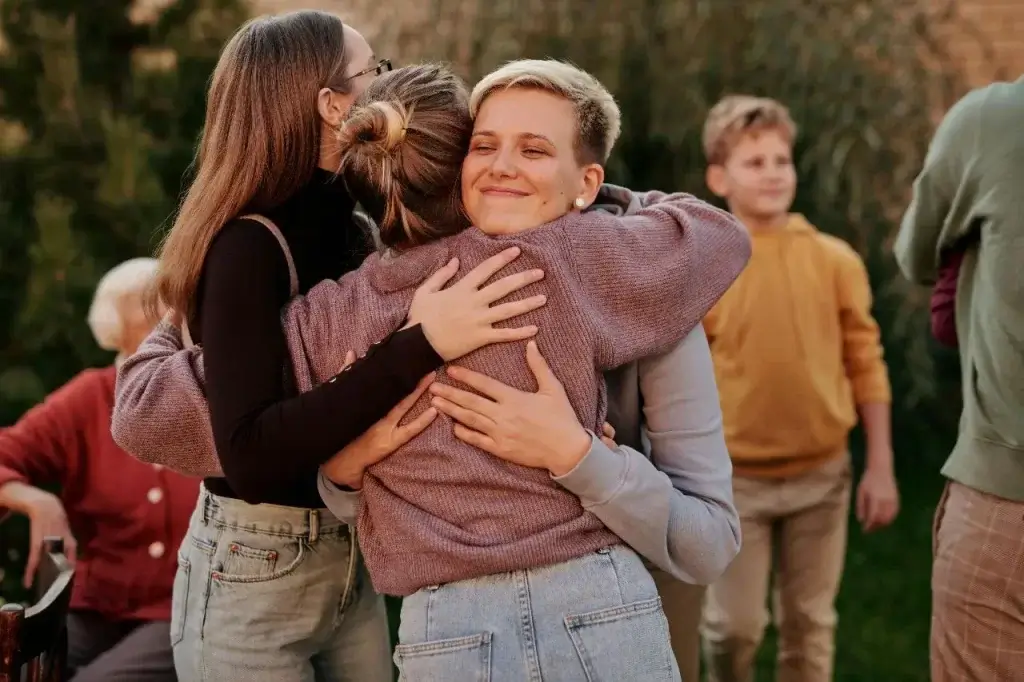 Picture of three women embracing, demonstrating that they are not alone in their first month in Germany.