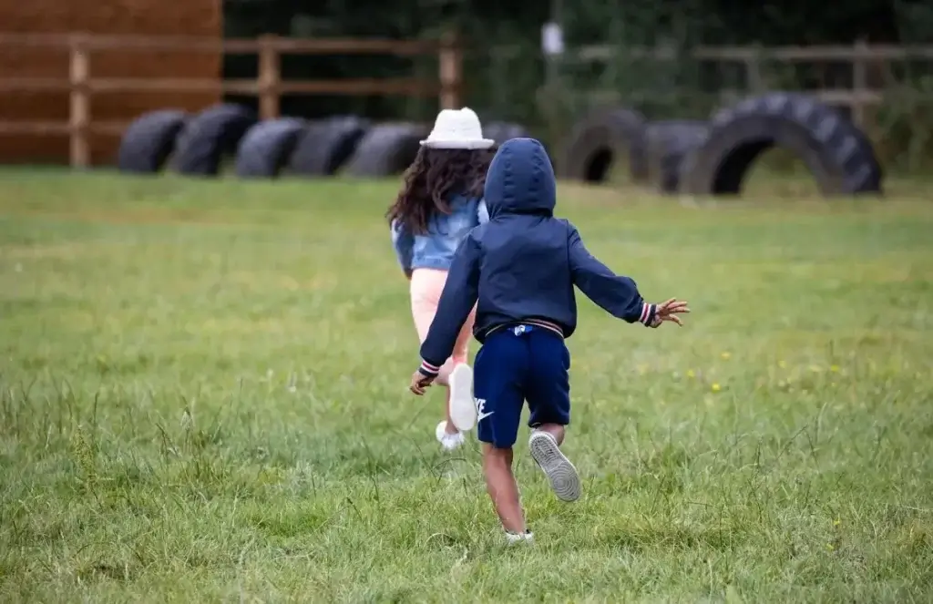 Two tweens running around on the grass.