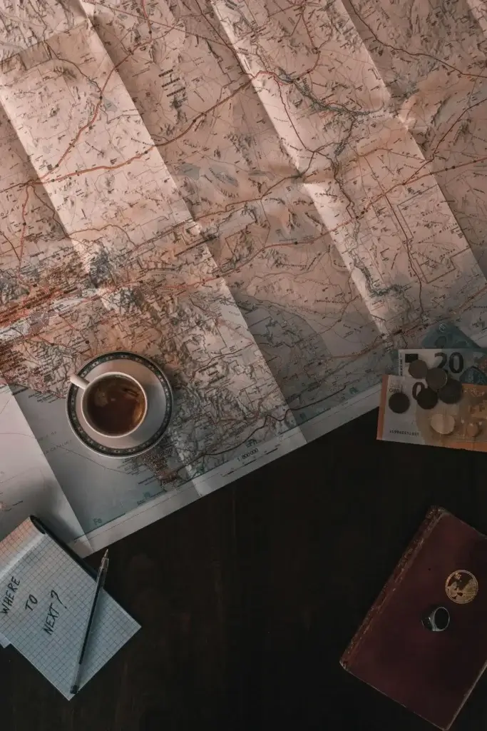 Image of a map, coffee and notepad, the essential planning items in addition to a family budget.