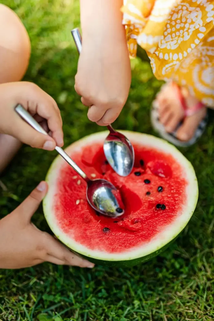 Kids eating watermelon, the perfect snack option to beat jet lag with kids.
