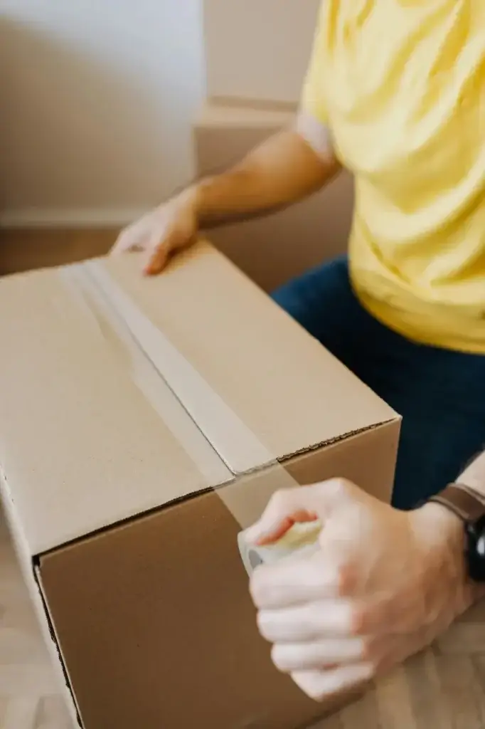 A Mother taping up a moving box before her relocation with her family abroad.