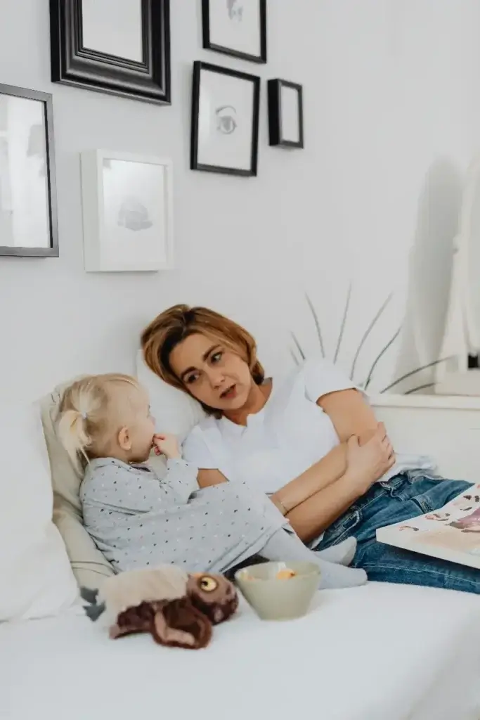 A Mother and daughter snuggled on the couch, talking about their planned international relocation.