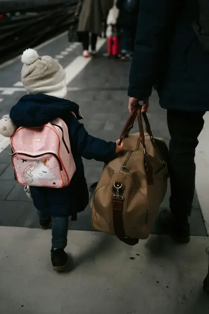 A child with her own backpack for her international move.