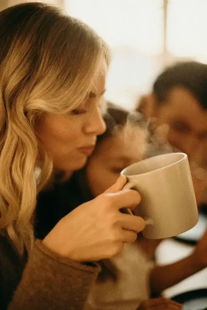 Mother enjoying a cup of coffee with her family, finally starting to feel herself again after her international move.